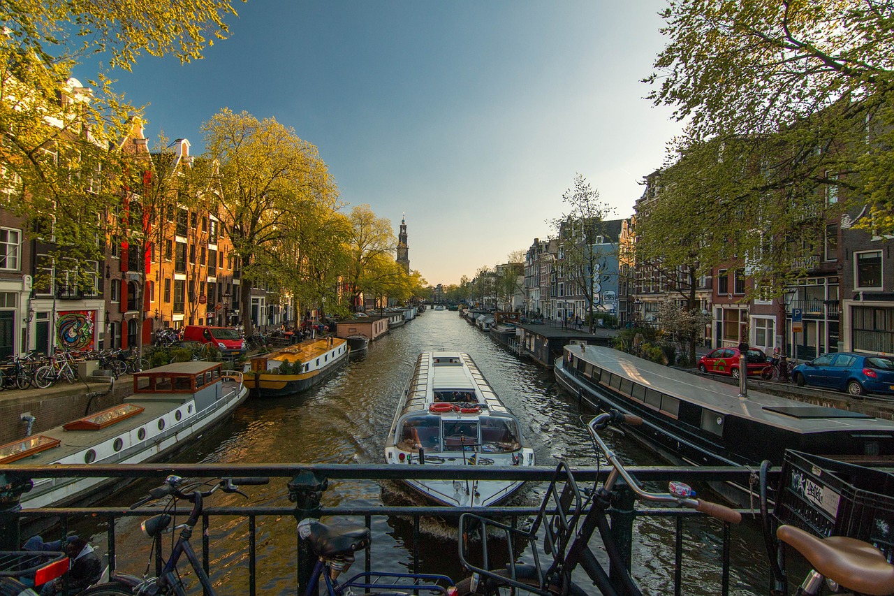 A scenic canal in a city with boats and historic buildings, showcasing the beauty of exploring new places with Smiley Travel and making unforgettable memories.